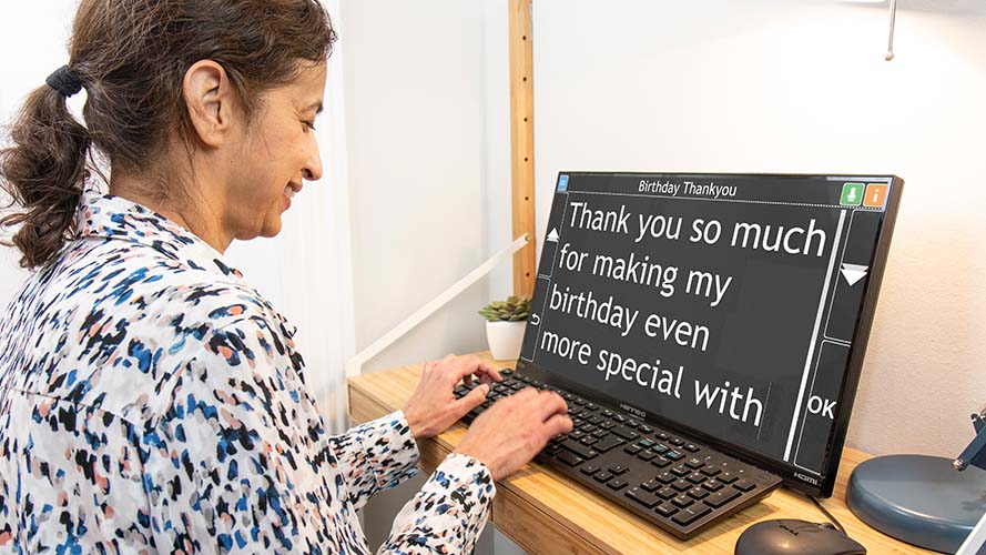 A senior woman using GuideConnect on a PC to type an email.